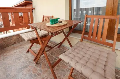 a wooden table and two chairs on a balcony at Designer apartment at Pirin Sense in Bansko