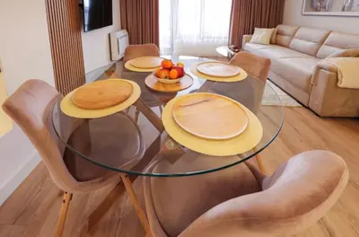 a living room with a glass table and chairs at Designer apartment at Pirin Sense in Bansko