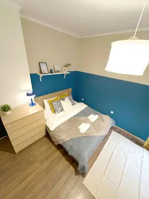 a bedroom with a bed and a blue wall at Echoes of Comfort - Top Center 1 BDR Fast Wi-fi in Sofia
