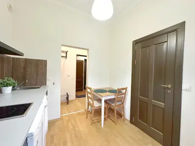 a kitchen with a table and chairs and a door at Echoes of Comfort - Top Center 1 BDR Fast Wi-fi in Sofia