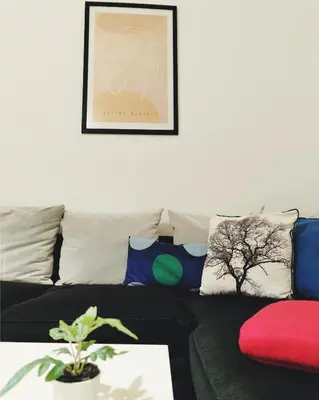 a living room with a black couch and pillows at Apartment for four next to blvd Vitosha in Sofia