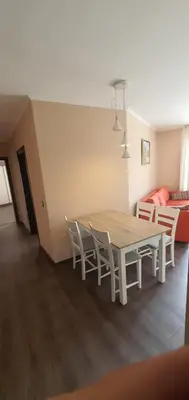 a dining room with a table and chairs and a couch at GONDOLA APARTMENTS BANSKO - SUVOROV VIP Complex in Bansko
