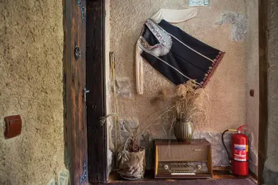 a room with a table with an umbrella on a wall at Самостоятелна къща за гости с изглед към планината Вила Марк in Kraevo