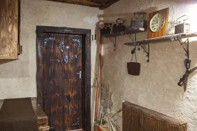 a room with a wooden door and a clock on the wall at Самостоятелна къща за гости с изглед към планината Вила Марк in Kraevo
