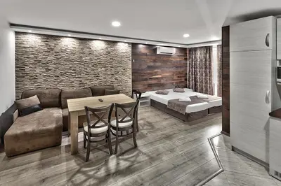 a living room with a couch and a table and chairs at Hotel Elit in Sandanski
