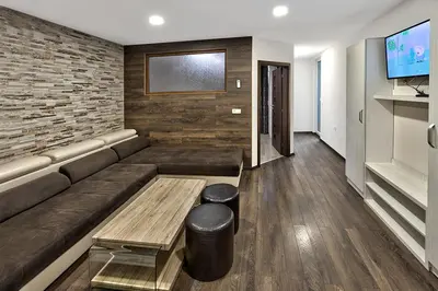 a living room with a couch and a tv at Hotel Elit in Sandanski