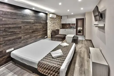a bedroom with a bed and a chair in a room at Hotel Elit in Sandanski