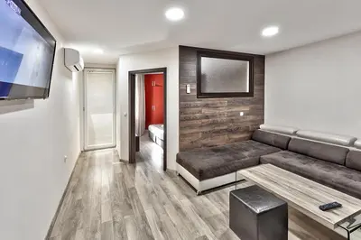 a living room with a couch and a flat screen tv at Hotel Elit in Sandanski
