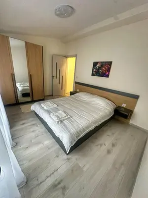 a bedroom with a large bed and a wooden floor at Nikos Apatament in Velingrad