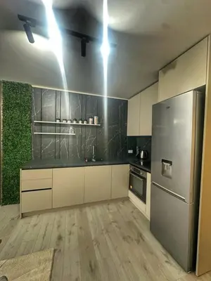 a kitchen with white cabinets and a stainless steel refrigerator at Nikos Apatament in Velingrad