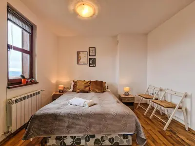 a bedroom with a bed and a window at Mountain View Studio, Steps from Bansko Gondola by Flat Mаnager in Bansko