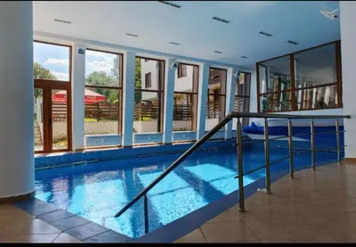 a large swimming pool in a building with windows at Mountain View Studio, Steps from Bansko Gondola by Flat Mаnager in Bansko