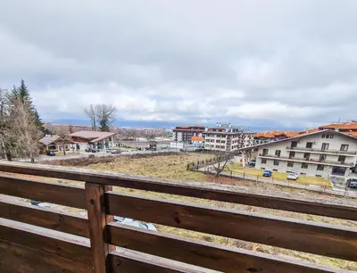 a view of a city from a wooden fence at Mountain View Studio, Steps from Bansko Gondola by Flat Mаnager in Bansko