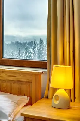 a lamp sitting on a table in front of a window at Alpine Haven 2-Bedroom Escape, Pamporovo by Flat Mаnager in Pamporovo