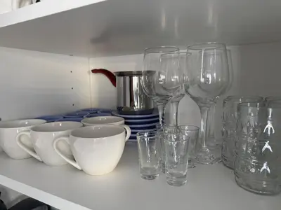 a bunch of glasses and cups on a shelf at La Mont Apartment Bansko in Bansko
