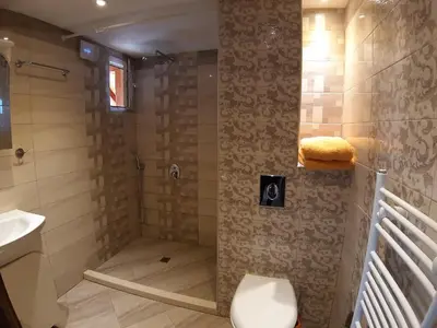 a bathroom with a shower with a toilet and a sink at Tora Bora Guest House in Pancharevo