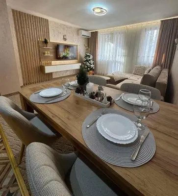 a living room with a table with plates and wine glasses at Raya Apart Pamporovo in Pamporovo