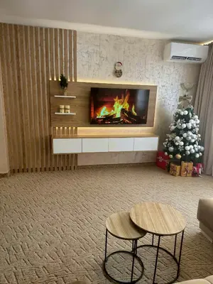 a living room with a fireplace and a christmas tree at Raya Apart Pamporovo in Pamporovo