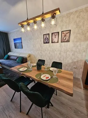 a dining room with a table and a couch at Viva 4-A-23 Apartment ski to the door complex Grand Monastery Pamporovo in Pamporovo