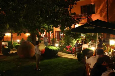 a group of people sitting outside a restaurant at night at Anita Guest House & Relax in Perushtitsa