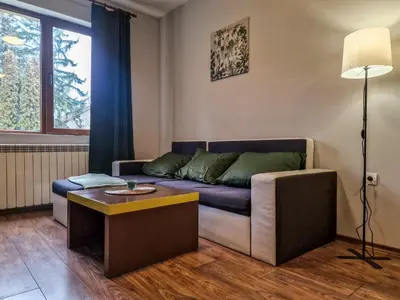 a living room with a couch and a table at Charming Mont Blanc Bansko Apartment Near Ski Lift by Flat Mаnager in Bansko