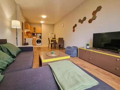 a living room with a couch and a flat screen tv at Charming Mont Blanc Bansko Apartment Near Ski Lift by Flat Mаnager in Bansko