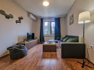 a living room with a couch and a table at Charming Mont Blanc Bansko Apartment Near Ski Lift by Flat Mаnager in Bansko