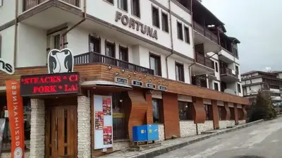 a building with a sign in front of it at Ski Lift Apartment - FORTUNA in Bansko
