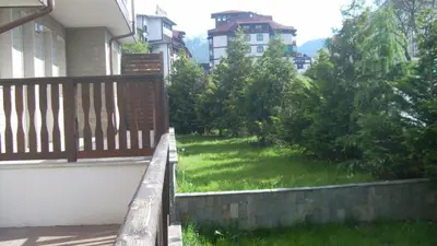 a balcony with a yard with green grass at Ski Lift Apartment - FORTUNA in Bansko