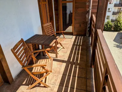 two chairs and a table on the porch of a house at Bansko holiday apartments - Mountain View Resort in Bansko