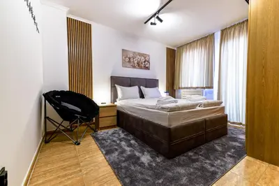 a bedroom with a bed and a chair in it at Yeti Apartment Pamporovo Grand Monastery in Pamporovo