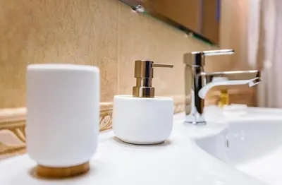 a bathroom with two soap dispensers on a sink at Yeti Apartment Pamporovo Grand Monastery in Pamporovo