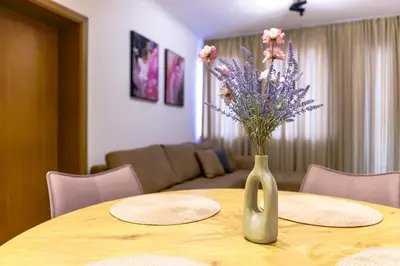 a vase with flowers on a table in a living room at Yeti Apartment Pamporovo Grand Monastery in Pamporovo
