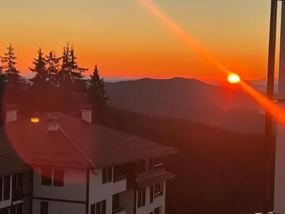 a sunset view from a building with the sun setting at Bambi in Pamporovo