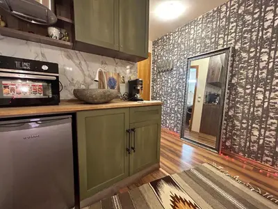 a kitchen with green cabinets and a wall with graffiti at Bambi in Pamporovo