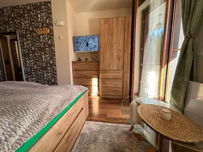 a bedroom with a bed and a table and a window at Bambi in Pamporovo