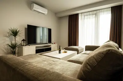 a living room with a couch and a flat screen tv at Къщи за гости ПАВЛЕВСКИ in Banya