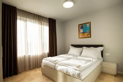 a bedroom with a bed and a large window at Къщи за гости ПАВЛЕВСКИ in Banya