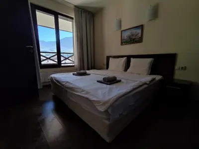 a bedroom with a large bed with a large window at Aspen Apartment A409 3OOm from Gondola in Bansko