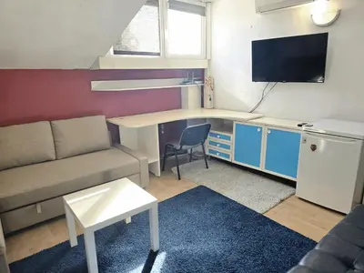 a small living room with a couch and a desk at The Little Pearl of Sofia in Sofia