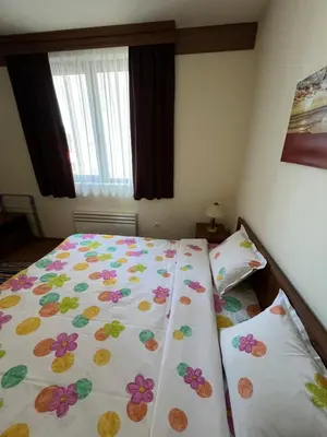 a bedroom with a bedspread with flowers on it at Edelweiss Apartment in Bansko