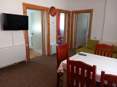 a living room with a tv and a table and chairs at ViBo Guesthouse in Sapareva Banya