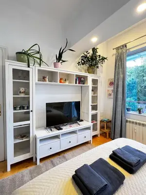 a bedroom with a white entertainment center with a flat screen tv at Christine's Apartment in Sofia