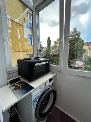 a laundry room with a washing machine and a window at Christine's Apartment in Sofia