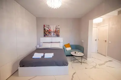 a bedroom with a large bed and a chair at Luxury Studios in Top Center in Sofia