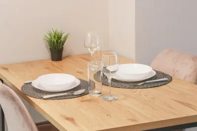 a wooden table with plates and wine glasses on it at Luxury Studios in Top Center in Sofia