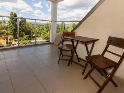a balcony with two wooden chairs and a table at MezonetCentre in Sofia