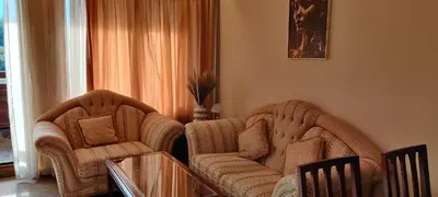 a living room with two chairs and a couch at Downtown Resort Bansko- Eliko Suite in Bansko