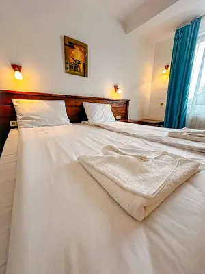 a large white bed with a blanket on it at Banderitsa Hotel and Casino in Bansko