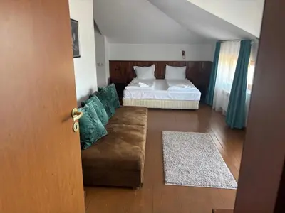 a living room with a bed and a couch at Banderitsa Hotel and Casino in Bansko